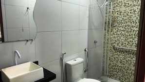 Un baño con lavamanos, inodoro y ducha.