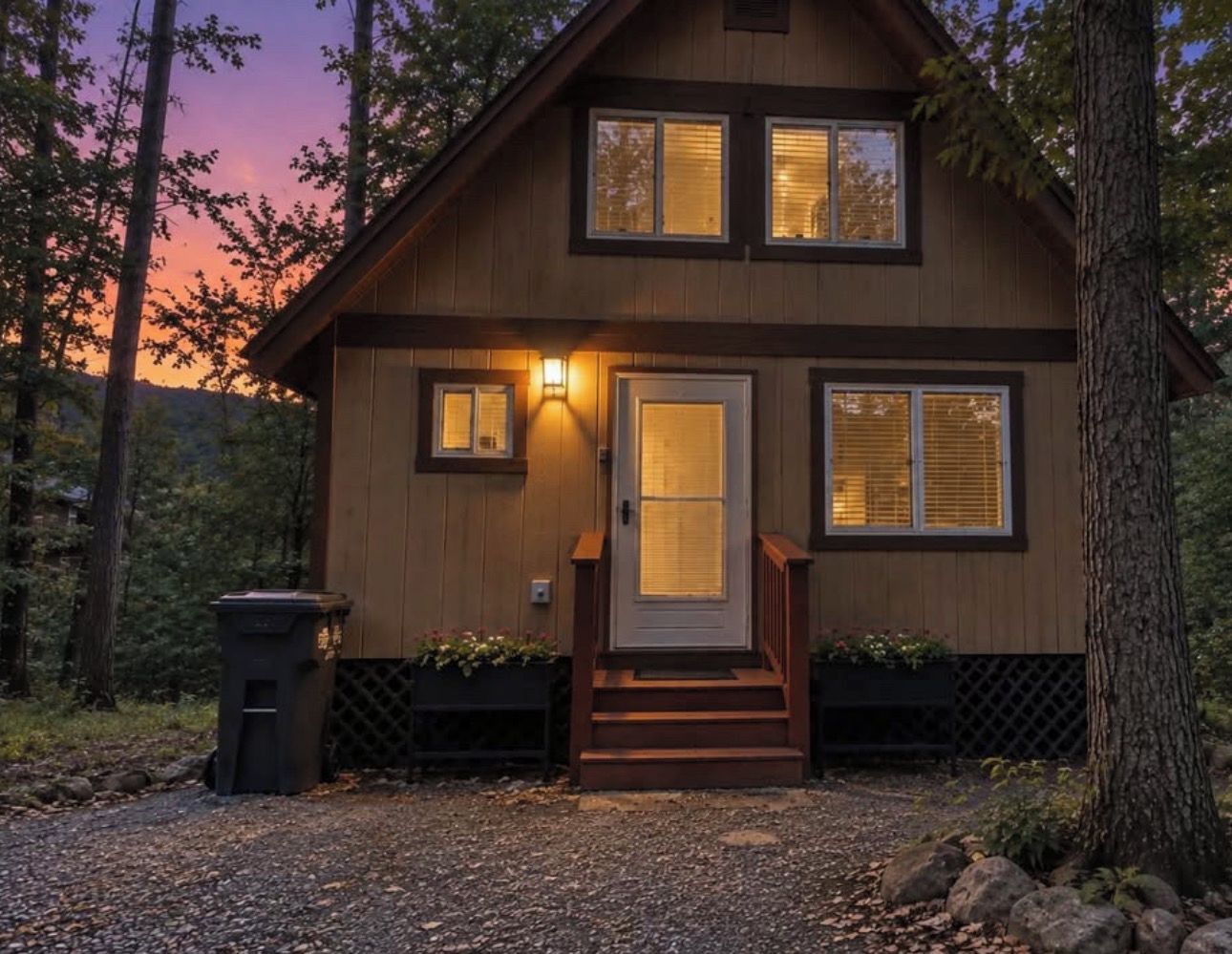 A wooden cabin with a front door, two windows, and a small porch with steps.