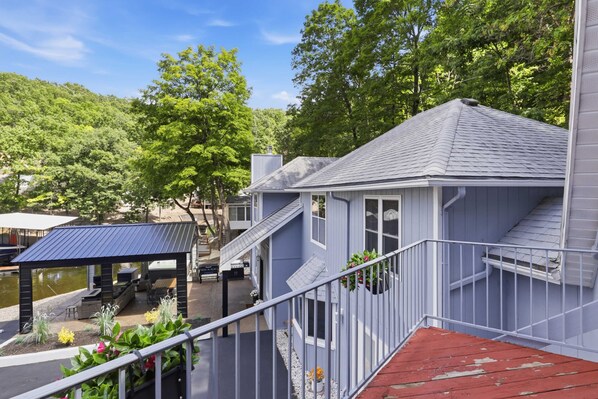 Ein Ufergrundstück mit überdachter Terrasse, Sitzgelegenheiten im Freien und einer Treppe zu einer zweiten Ebene.