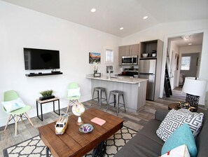A modern living room with a flat-screen TV, a wooden coffee table, and a sofa. - Unique Escape for Four near the Zion National Park, Utah (Orderville)