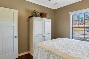 Ein Schlafzimmer mit Bett, Kleiderschrank und einem Fenster mit Blick.