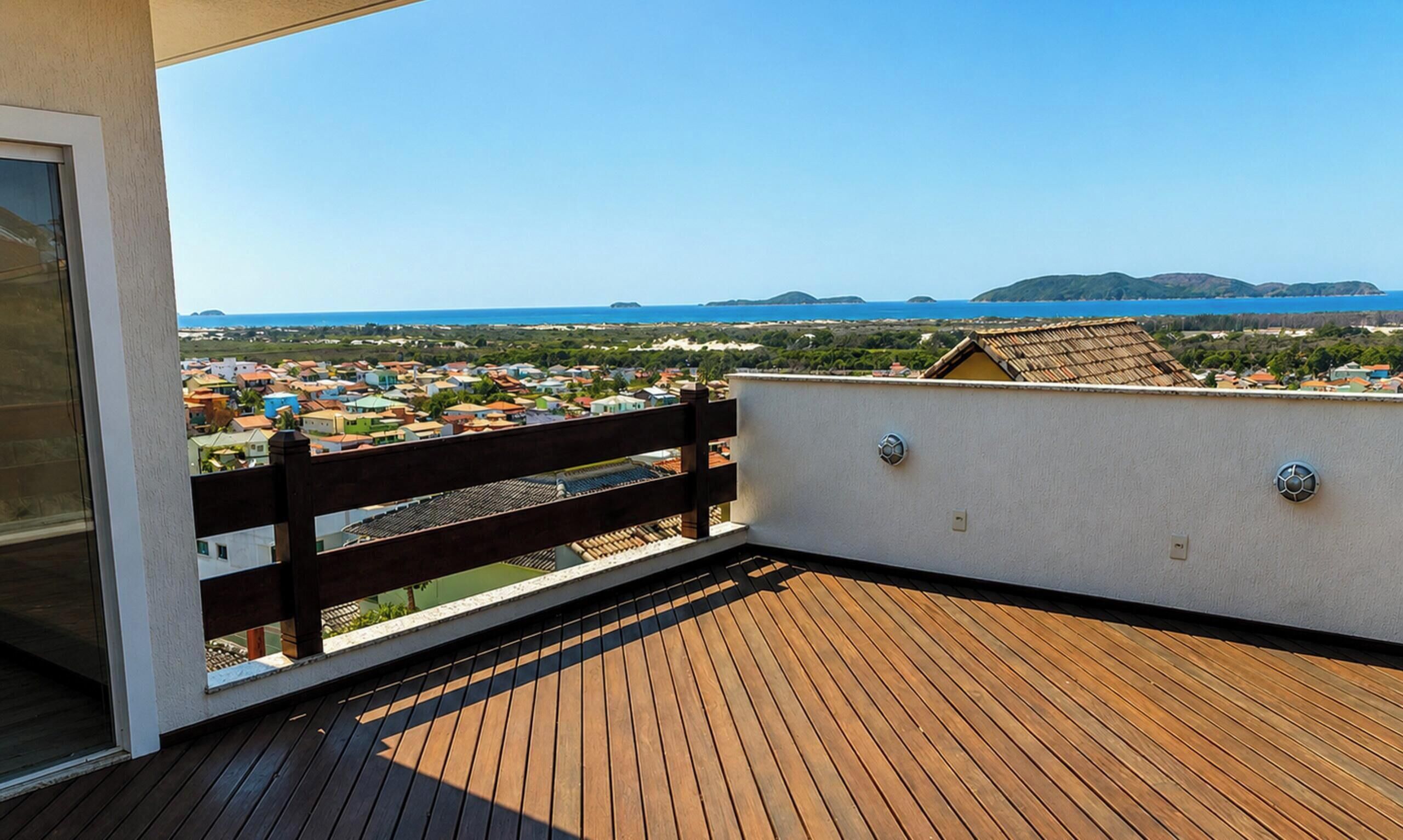 A wooden deck with a view of a coastal town and the sea.