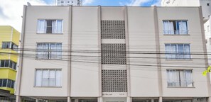 Un immeuble à plusieurs étages doté d’une section verticale centrale et d’une façade ornée de motifs.