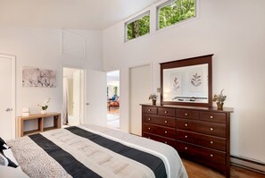 A bedroom with a large bed, a dresser, a mirror, and a door leading to a balcony. - Awesome Cabin with Barbecue in Berkeley Springs, West Virginia (Berkeley Springs)