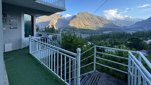 Een balkon met uitzicht op bergen en een rivier.