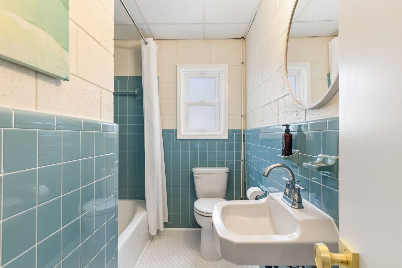 A bathroom with a toilet, sink, and shower area.