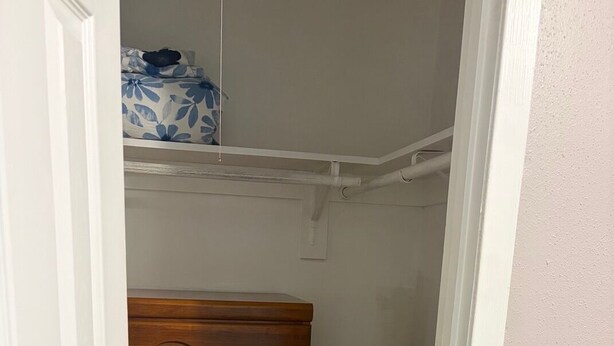 A narrow hallway with a wooden dresser and a white door.