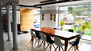 A dining area with a large wooden table and modern chairs, a hanging laundry rack, and a view of greenery outside. - Spacious 5-bedroom MANSION in tranquil Guarne perfect for families & events (Guarne)