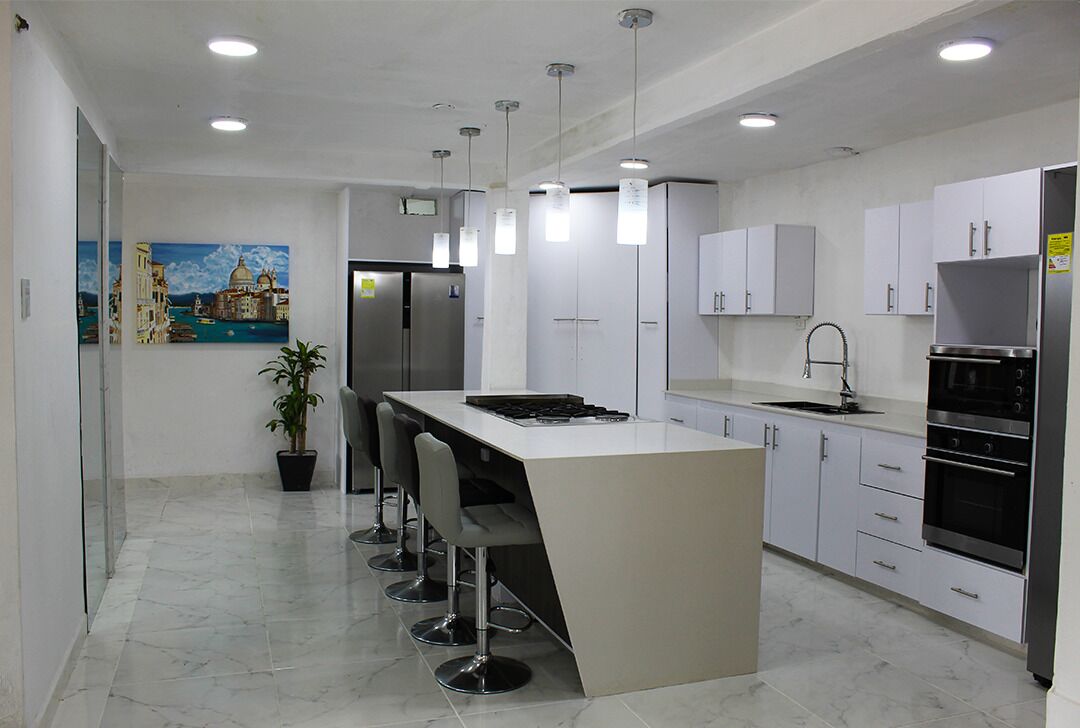 A modern kitchen with a central island, bar stools, stainless steel appliances, and a painting of a cityscape.