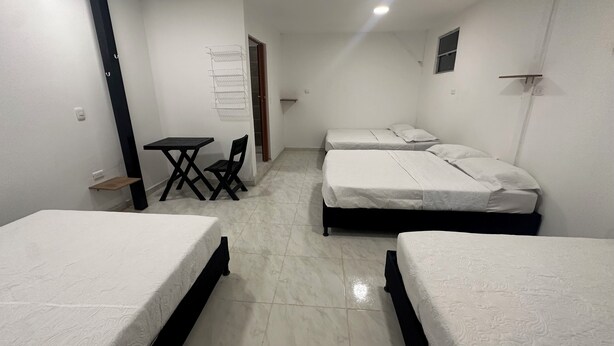 A room with three beds, a small table, and a chair. - Spacious 5-bedroom MANSION in tranquil Guarne perfect for families & events (Guarne)