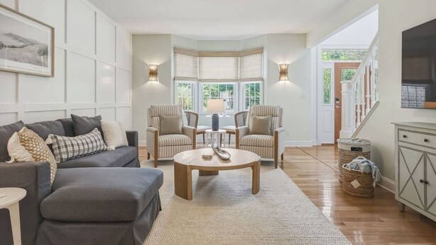 A modern living room with a sofa, armchairs, a coffee table, and a dining table. - The Grand Carolina | Golf Cart ·Hot Tub ·4BR ·PKS (Pine Knoll Shores)