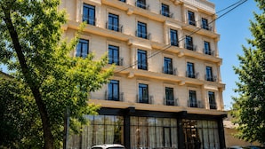 Um hotel de vários andares com fachada simétrica, grandes janelas e varandas.