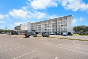 Ein mehrstöckiges Hotel mit Parkplatz davor.
