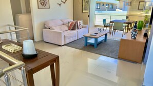 Una sala moderna con un sofá, una mesa de centro y un comedor con sillas y una mesa.
