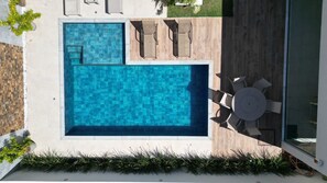 A rooftop pool with a view of the city, surrounded by a deck with chairs and a table. - Casa Cherne | just 100 meters from the sea in the Paraíso Condominium in Guarajuba (Camaçari)