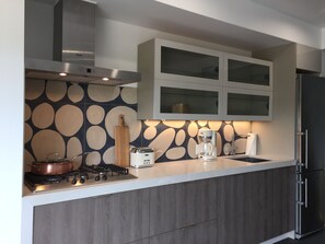 Una cucina moderna con piano cottura a gas, macchina da caffè e frigorifero.