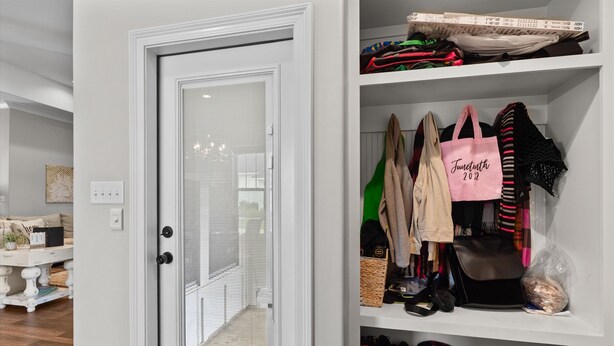 A white closet with shelves containing bags, jackets, and shoes. - Fully Furnished 4-Bedroom Executive Home (Stonewall)