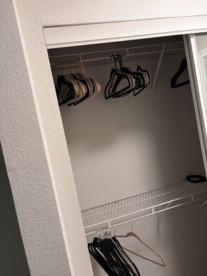 A closet with hanging clothes and a shelf. - Just 6 mins from
Braves Stadium , 8 miles from Benz Stadium & State Farm Arena (Atlanta)