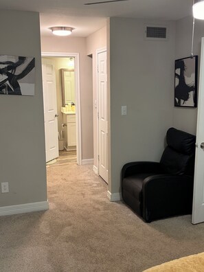 A hallway with carpeted flooring, white doors, and artwork on the walls. - Just 6 mins from
Braves Stadium , 8 miles from Benz Stadium & State Farm Arena (Atlanta)