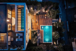Ein modernes Haus mit Swimmingpool, Sitzgelegenheit im Freien und einer Terrassenfläche.