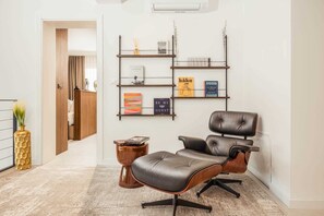 A modern office space with a leather chair, a bookshelf with various items, and a wooden door leading to another room. - Villa Aquarama with Pool (Okrug Gornji)