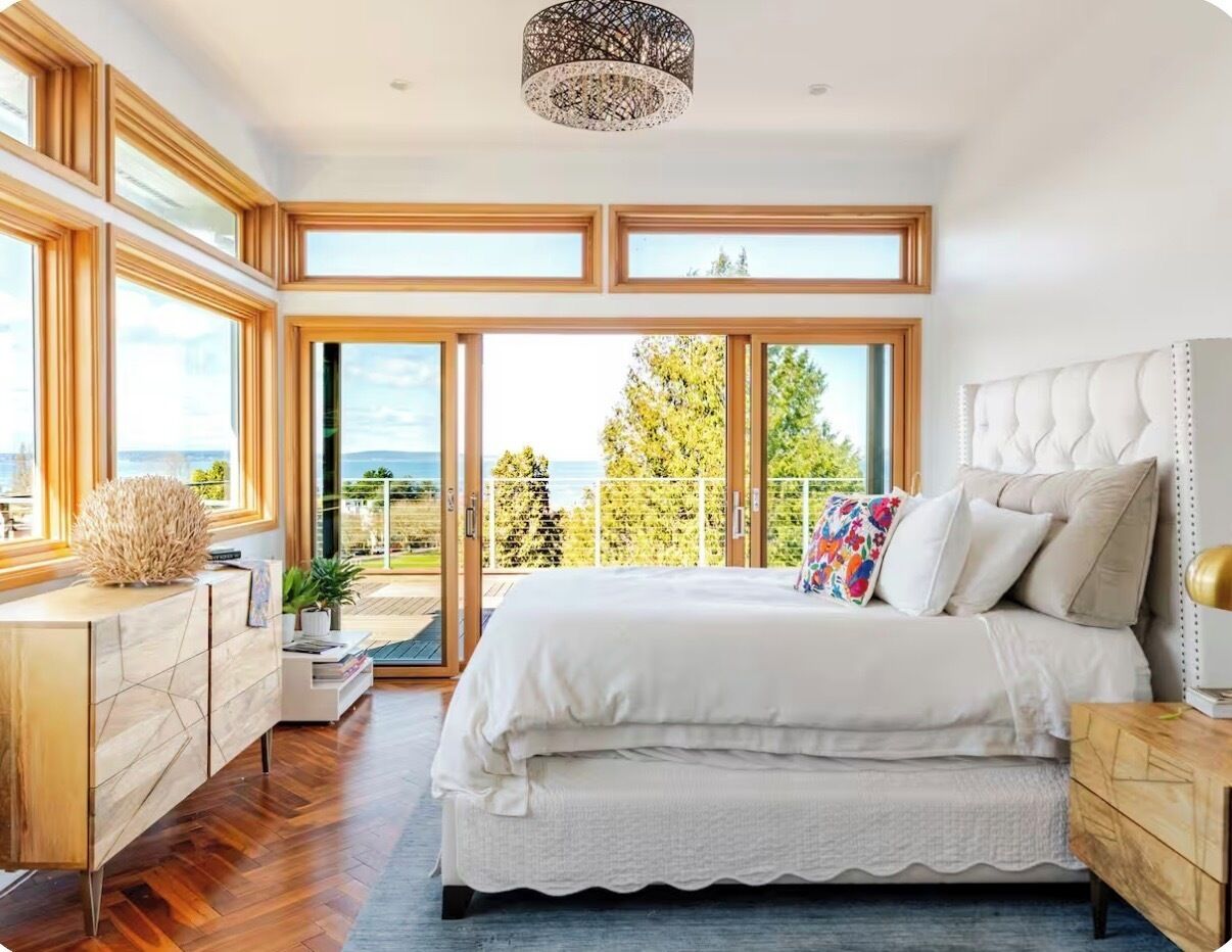 Une chambre avec un grand lit, un bureau et une vue sur l’extérieur.