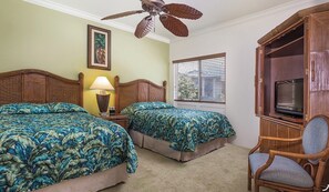Ein Hotelzimmer mit zwei Betten, einem Deckenventilator, einem Fernseher und einem Fenster mit Jalousien.
