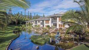 Un resort con piscina, una piccola cascata e vista su una catena montuosa.