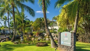 Un resort tropicale con un cartello che riporta 'Wyndham', circondato da palme e un piccolo stagno.