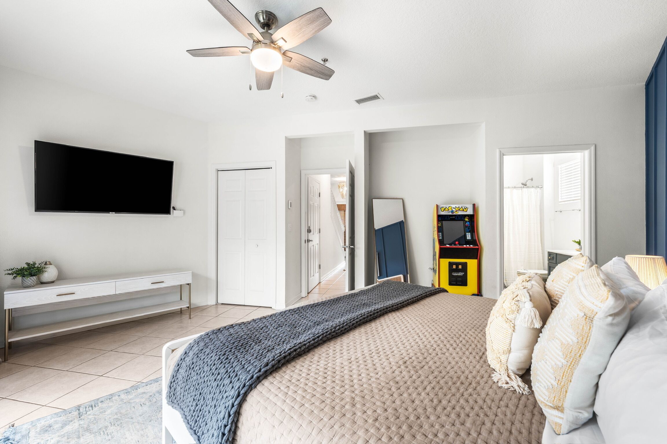 Bright bedroom with TV, en suite bath, and fun retro arcade game