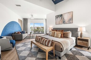 A modern hotel room with a large bed, a sofa, a desk, and a balcony with a view. - 3BR/3Bath, Steps to Private Beach Access! (Destin)