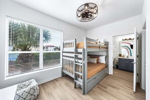 A child's bedroom with bunk beds, a window with blinds, a small stool, and a ceiling light fixture. - 3BR/3Bath, Steps to Private Beach Access! (Destin)