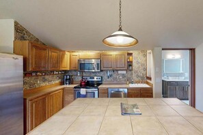 A kitchen with wooden cabinets, a stainless steel refrigerator, a microwave, an oven, and a hanging light fixture. - Lovely 3BR Oregon Wine Country - Washer & Dryer (McMinnville)