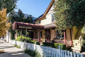 A two-story building with a covered porch and a sign reading 'BISTRO MAISON.' - Lovely 3BR Oregon Wine Country - Washer & Dryer (McMinnville)