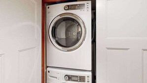 A compact, wall-mounted washer and dryer unit with a control panel and a digital display.