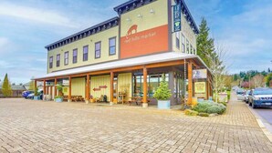 En toetages bygning med en overdækket veranda og et skilt, der siger 'Red Hills Market'.