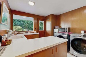 A modern kitchen with a large window, built-in appliances, and a clean layout. - 1BR Apartment - Washer & Dryer - Dog-Friendly (Portland)