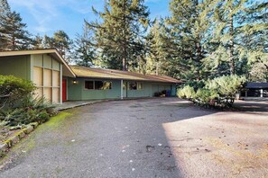 A single-story building with a sloped roof, a covered porch, and a paved driveway. - 1BR Apartment - Washer & Dryer - Dog-Friendly (Portland)