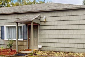 A single-story house with a covered porch, a front door, and a small garden area with mulch and plants. - 2BR peaceful getaway with patio & W&D - near river (Milwaukie)