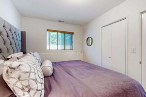 A bedroom with a bed, a window, a wardrobe, and a mirror. - 2BR peaceful getaway with patio & W&D - near river (Milwaukie)