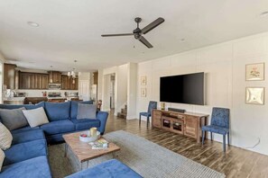 A modern living room with a sectional sofa, a coffee table, and a flat-screen TV. - 5BR House - Fire Pit - Gas Grill - Washer & Dryer (Newberg)