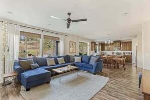 Ein modernes Wohnzimmer mit einem Ecksofa, einem Couchtisch und einem Essbereich mit einem Holztisch und Stühlen.