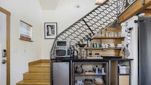 Et lille køkken med mikrobølgeovn, kaffemaskine og et minikøleskab.
