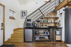 A compact kitchen with a microwave, coffee maker, and a small refrigerator. - Blue Door Micro-Loft in Hip and Arty Location (Portland)