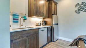 A kitchen with wooden cabinets, a stainless steel refrigerator, and a coffee maker. - High-End Studio Oregon Wine Country (McMinnville)