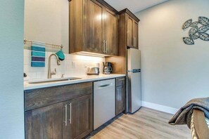 A kitchen with wooden cabinets, a stainless steel refrigerator, and a coffee maker. - High-End Studio Oregon Wine Country (McMinnville)