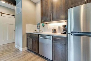 A modern kitchen with stainless steel appliances, wooden cabinets, and a white tiled backsplash. - High-End Studio Oregon Wine Country (McMinnville)
