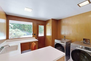 A compact laundry room with a washing machine, dryer, and sink. - 3BR home with pool, patio, fireplace, WIFI (Portland)