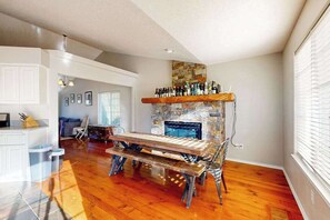 A spacious living area with a wooden bench, a stone fireplace, and a bar area with bottles. - 3BR Oregon Wine Country - Fireplace - Patio (McMinnville)