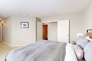 A bedroom with a bed, a door, and a wall-mounted picture. - 3BR Oregon Wine Country - Fireplace - Patio (McMinnville)